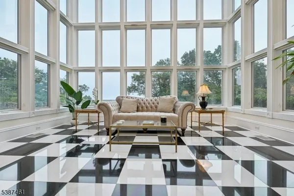 a living room with a black white checkered floor with a coffee table and chairs