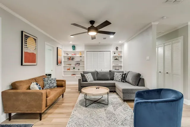 a living room with furniture and a ceiling fan