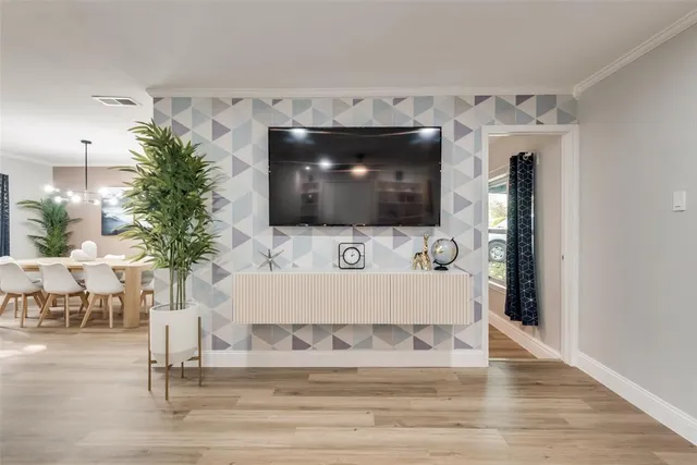 a living room with furniture kitchen view and a flat screen tv