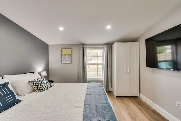 a bedroom with a bed and painting on the wall