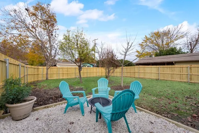 a view of a chair and table in backyard of the house