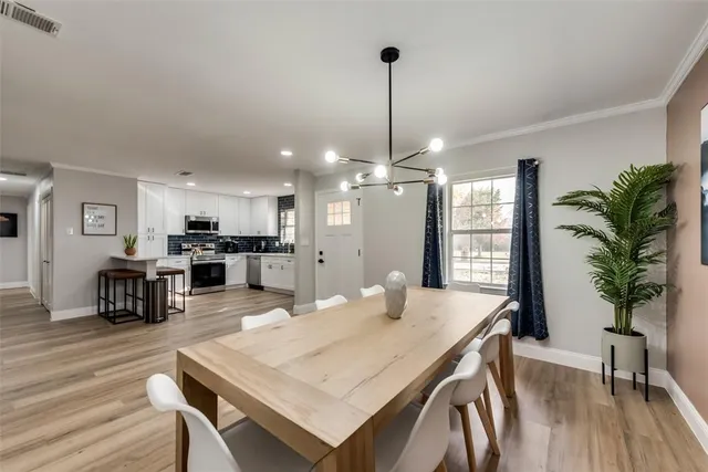 a view of a dining room and livingroom with furniture wooden floor a chandelier