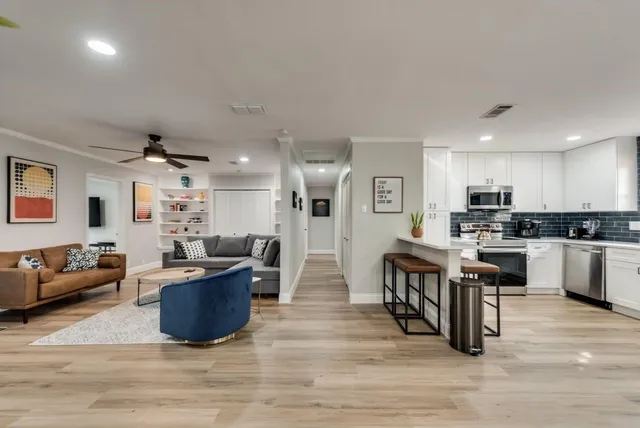 a living room kitchen with furniture and a wooden floor