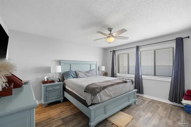 a bedroom with a bed a flat screen tv and a couch