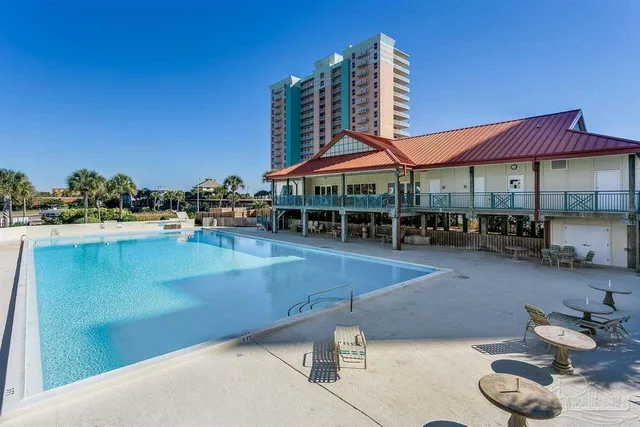 a living room with lots of chairs and kitchen view
