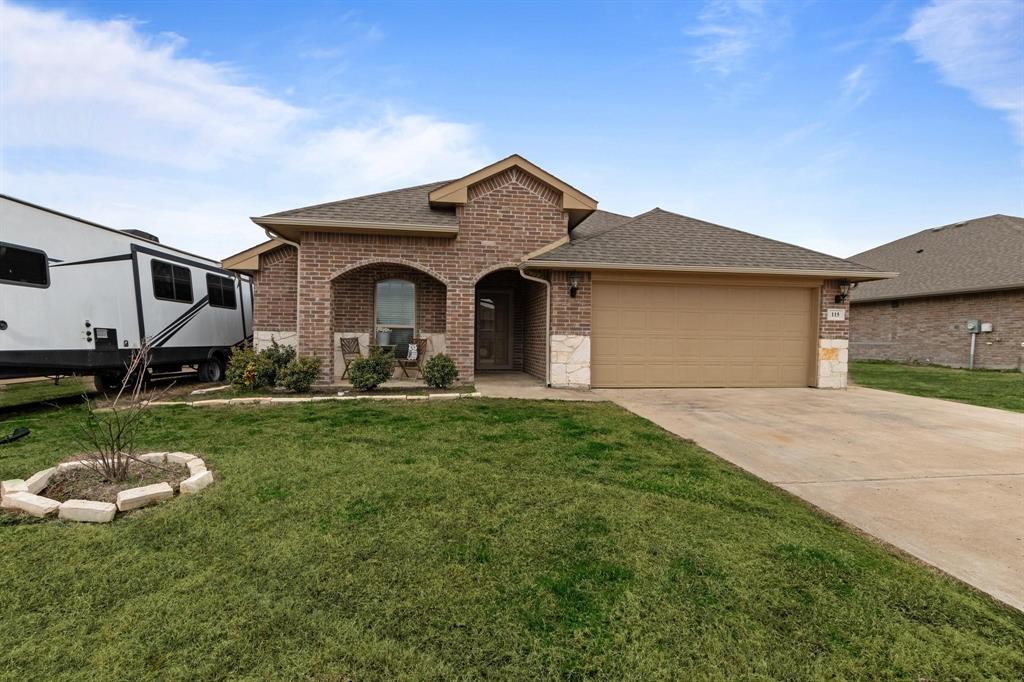 115 Oak Spgs Loop Mabank, TX 75147 - Photo 1 of 15 View of front of house featuring a shingled roof, brick siding, concrete driveway, and a front lawn
