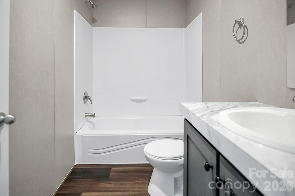 101 Park Lane Grover, NC 28073 - Photo 13 of 28 a bathroom with a granite countertop bathtub sink vanity mirror and toilet