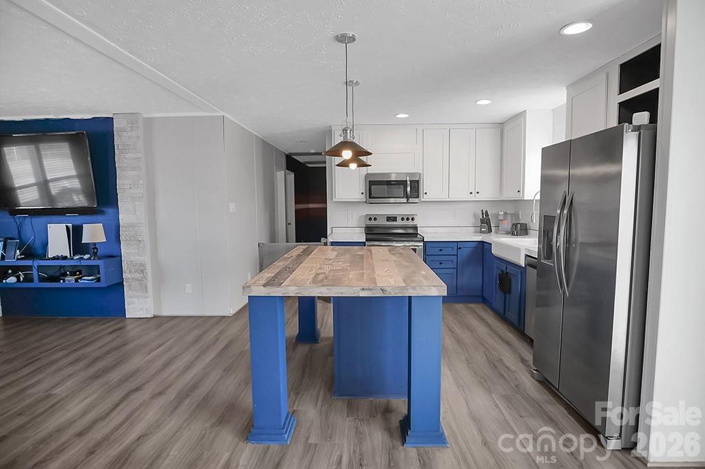101 Park Lane Grover, NC 28073 - Photo 8 of 28 a kitchen with kitchen island a wooden floor and a refrigerator
