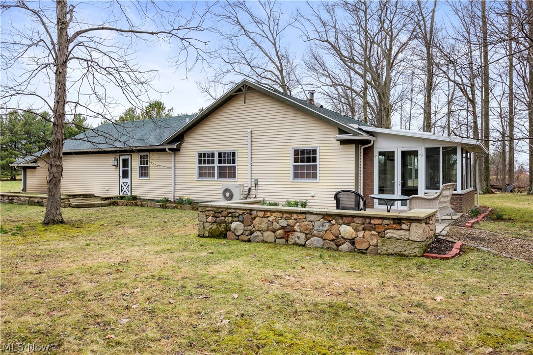 11923 Green Road Wakeman, OH 44889 - Photo 32 of 45 Rear view of house featuring a yard, a sunroom, a patio, and roof with shingles
