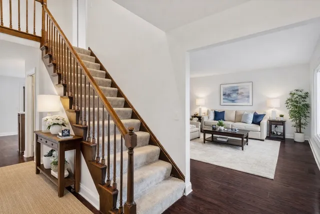a living room with couches and a dining table with wooden floor