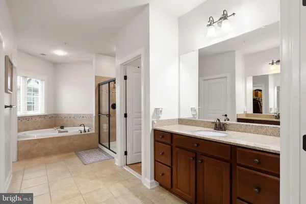 a spacious bathroom with a shower a sink and mirror