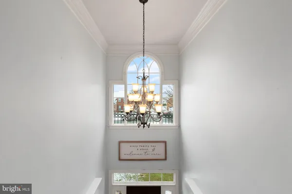 a view of a hallway with windows and chandelier