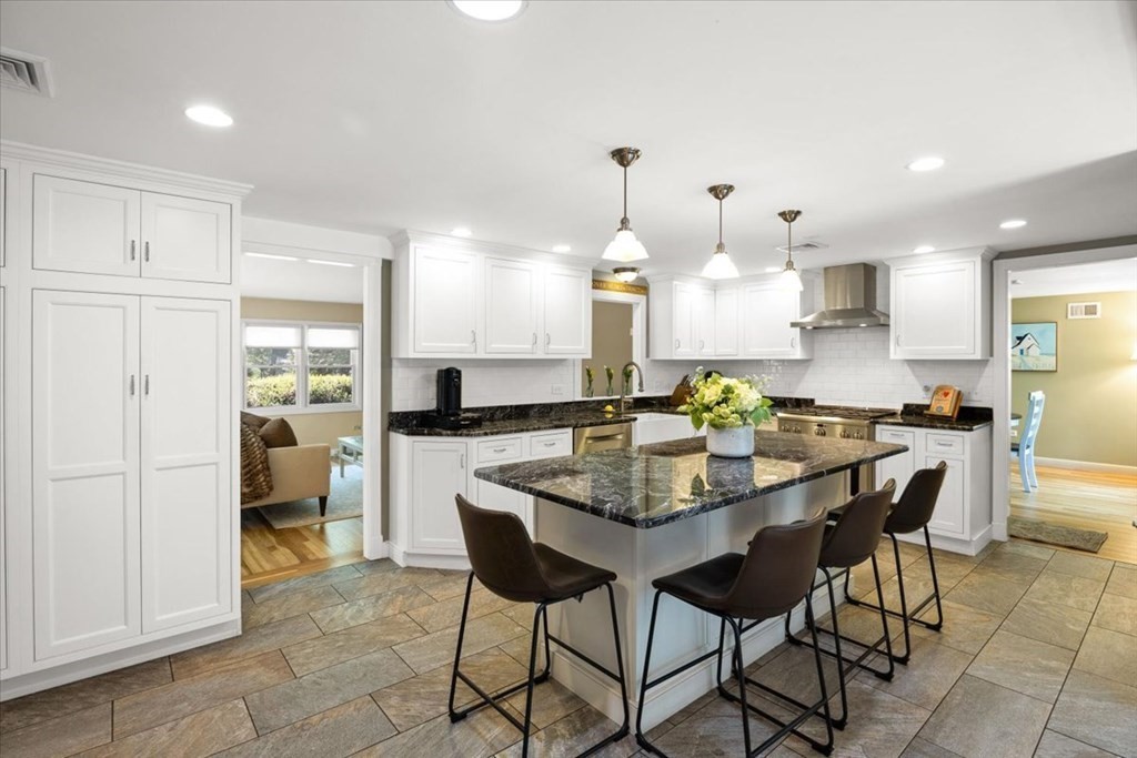 280 Broadway Hanover, MA 02339 - Photo 18 of 37 a kitchen with stainless steel appliances kitchen island granite countertop a table chairs and a refrigerator