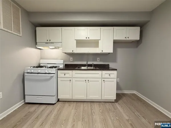 an empty room with a hardwood and windows