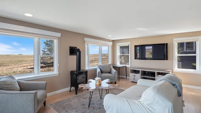 a living room with furniture tv and wooden floor