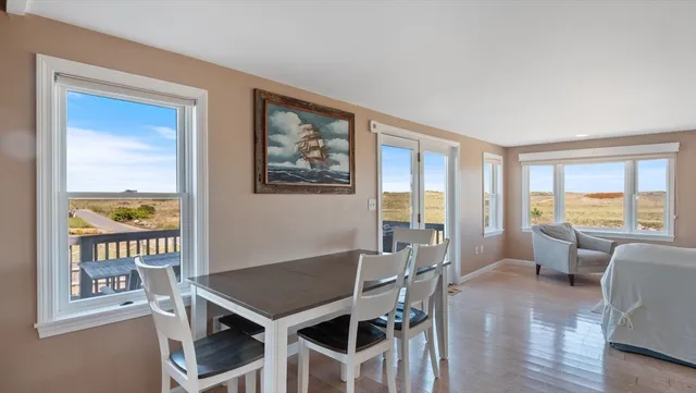 a dining room with furniture a window and wooden floor