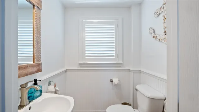a bathroom with a toilet sink and mirror