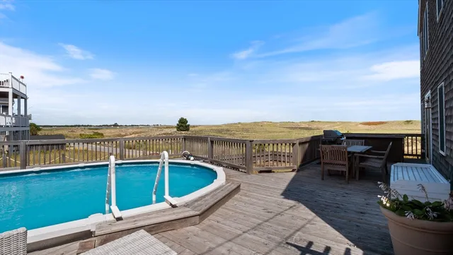 a view of a balcony with dining table and chairs with wooden floor