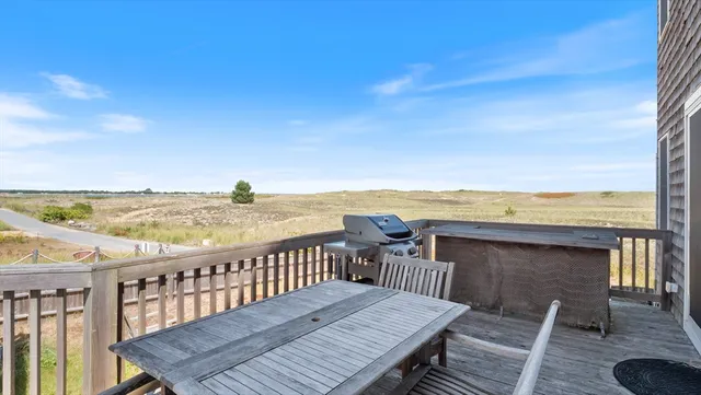 a view of a balcony with wooden floor and ocean view