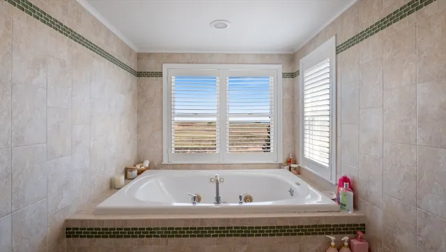 a bath tub sitting in a bathroom next to a window
