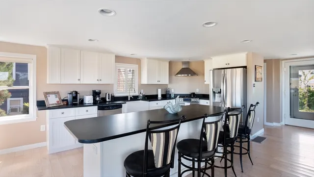 a kitchen with stainless steel appliances granite countertop a dining table chairs and granite counter tops