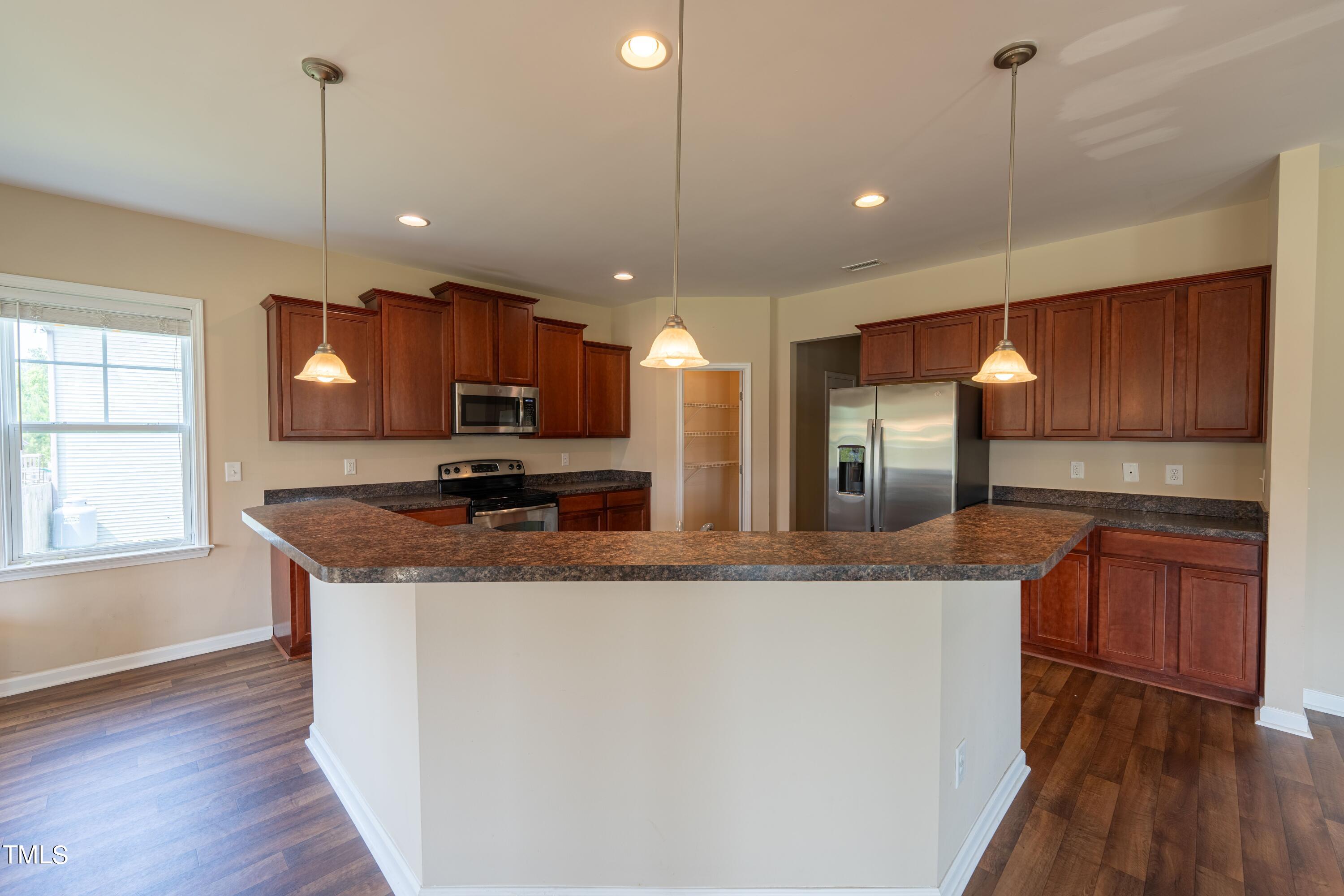 15 Lancaster Court Spring Lake, NC 28390 - Photo 15 of 48 a kitchen with stainless steel appliances granite countertop wooden cabinets a sink a center island and a window