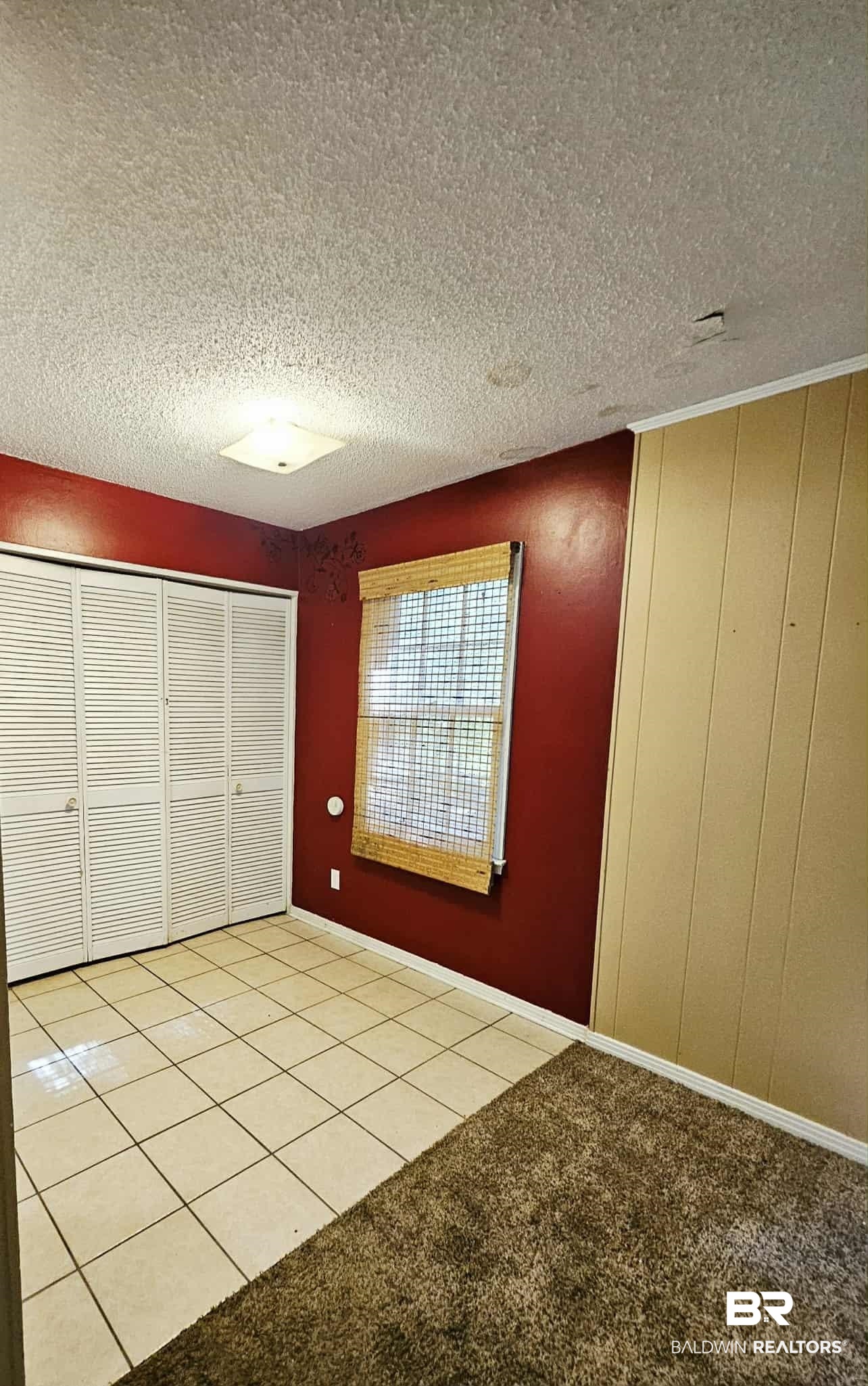 324 Vanderbilt Drive Mobile, AL 36608 - Photo 6 of 17 Unfurnished bedroom with light tile patterned flooring, a textured ceiling, a closet, and light colored carpet