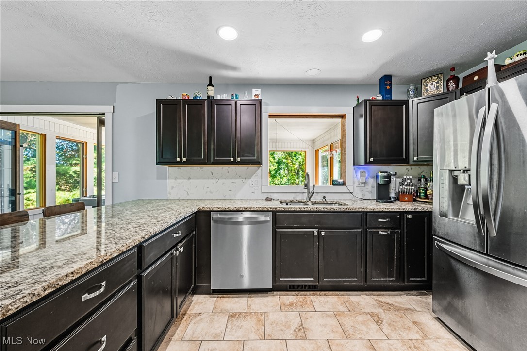 8193 Hartman Road Wadsworth, OH 44281 - Photo 11 of 50 Kitchen featuring appliances with stainless steel finishes, a textured ceiling, light stone counters, and recessed lighting