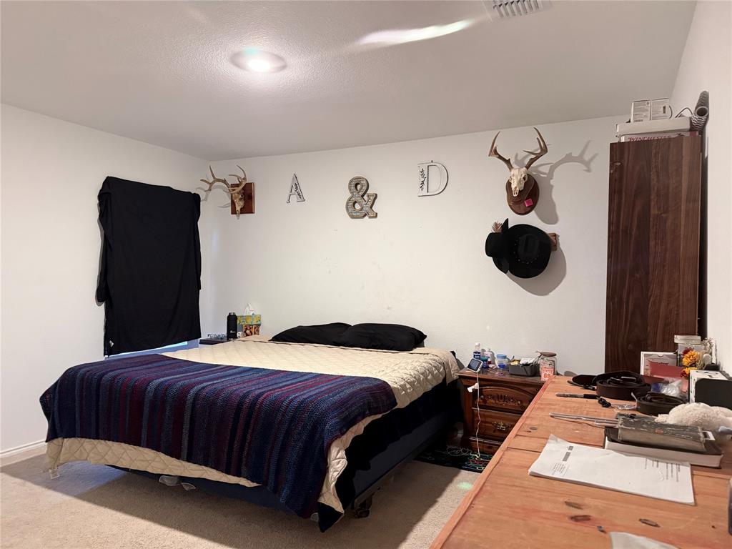 330 Ashbrook Way Princeton, TX 75407 - Photo 6 of 11 a bedroom with a bed and cabinets