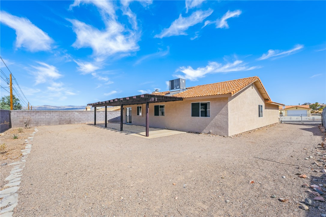 2524 South Ridge Avenue Bullhead City, AZ 86429 - Photo 52 of 64 Rear view of property featuring stucco siding, a patio area, a fenced backyard, a tiled roof, and central AC unit