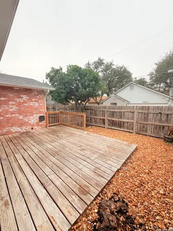 a view of a balcony with wooden floor and fence