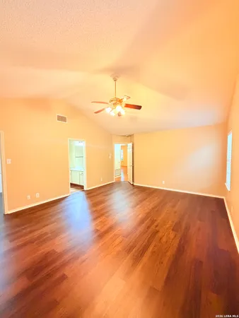 a view of a room with wooden floor and a ceiling fan