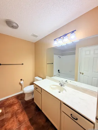 a bathroom with a granite countertop sink a toilet and a mirror