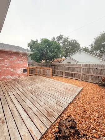 a view of a balcony with wooden floor and fence