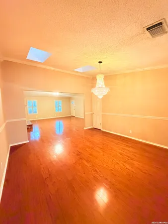 a view of a big room with wooden floor and windows