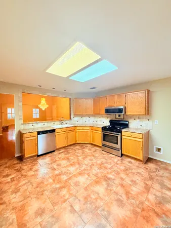 a large kitchen with stainless steel appliances kitchen island granite countertop a large counter top and a stove