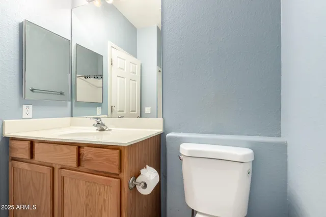 a bathroom with a toilet a sink and mirror