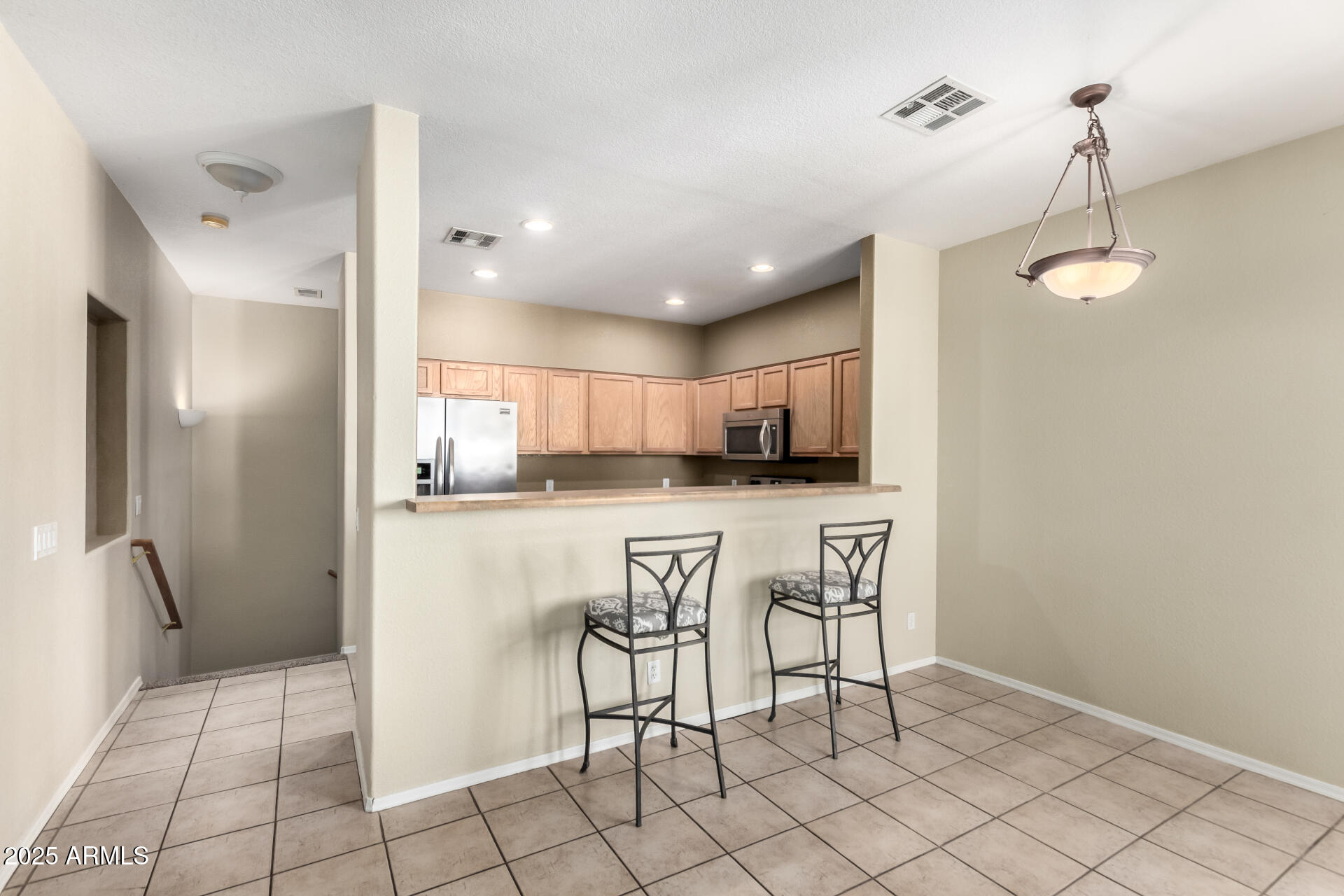 1335 East June Street, Unit 239 Mesa, AZ 85203 - Photo 9 of 34 a kitchen with stainless steel appliances kitchen island granite countertop a refrigerator and a sink