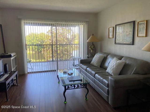 a living room with furniture and a flat screen tv with wooden floor