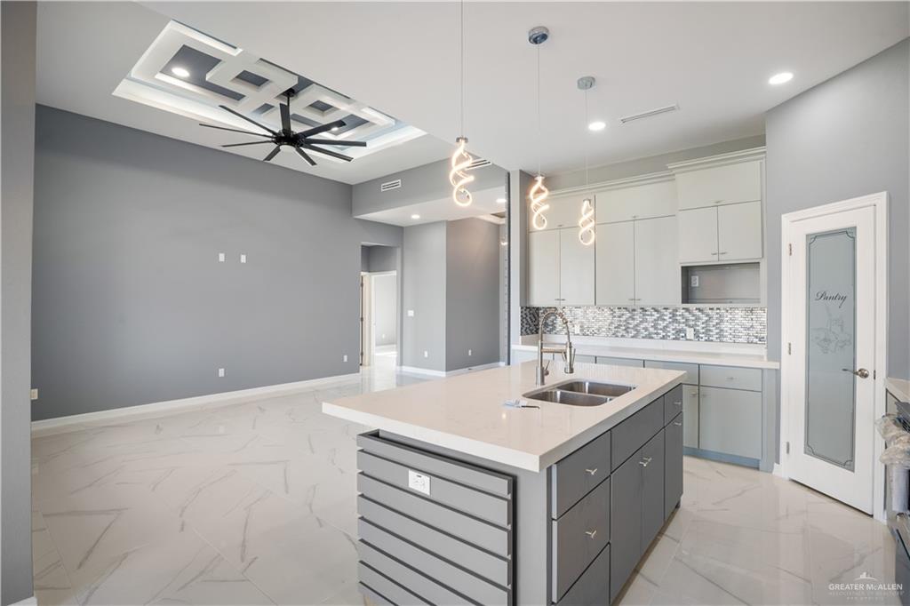 1402 Tee Box Drive Weslaco, TX 78596 - Photo 4 of 20 a kitchen with a sink a counter top space and stainless steel appliances