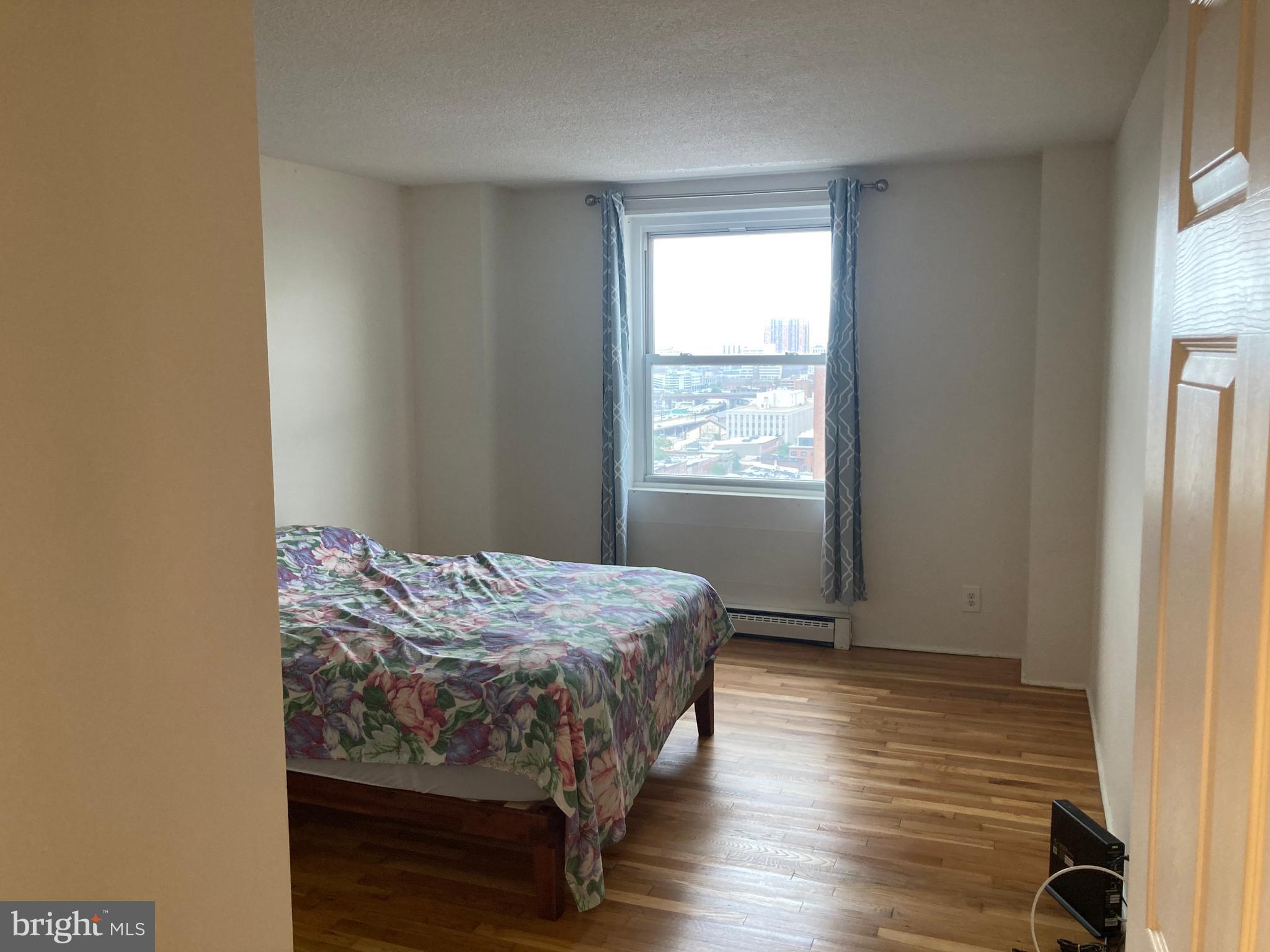 1101 St Paul Street, Unit 1403 Baltimore, MD 21202 - Photo 2 of 13 a bedroom with a bed and a window