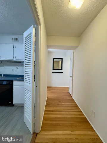a view of a hallway with wooden floor and staircase