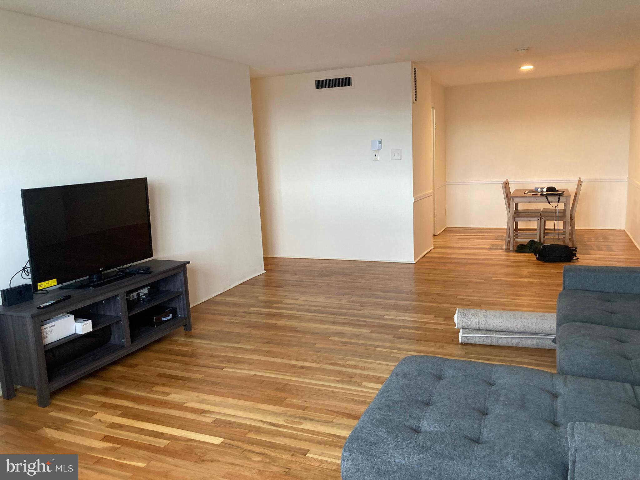 1101 St Paul Street, Unit 1403 Baltimore, MD 21202 - Photo 4 of 13 a living room with furniture and a flat screen tv