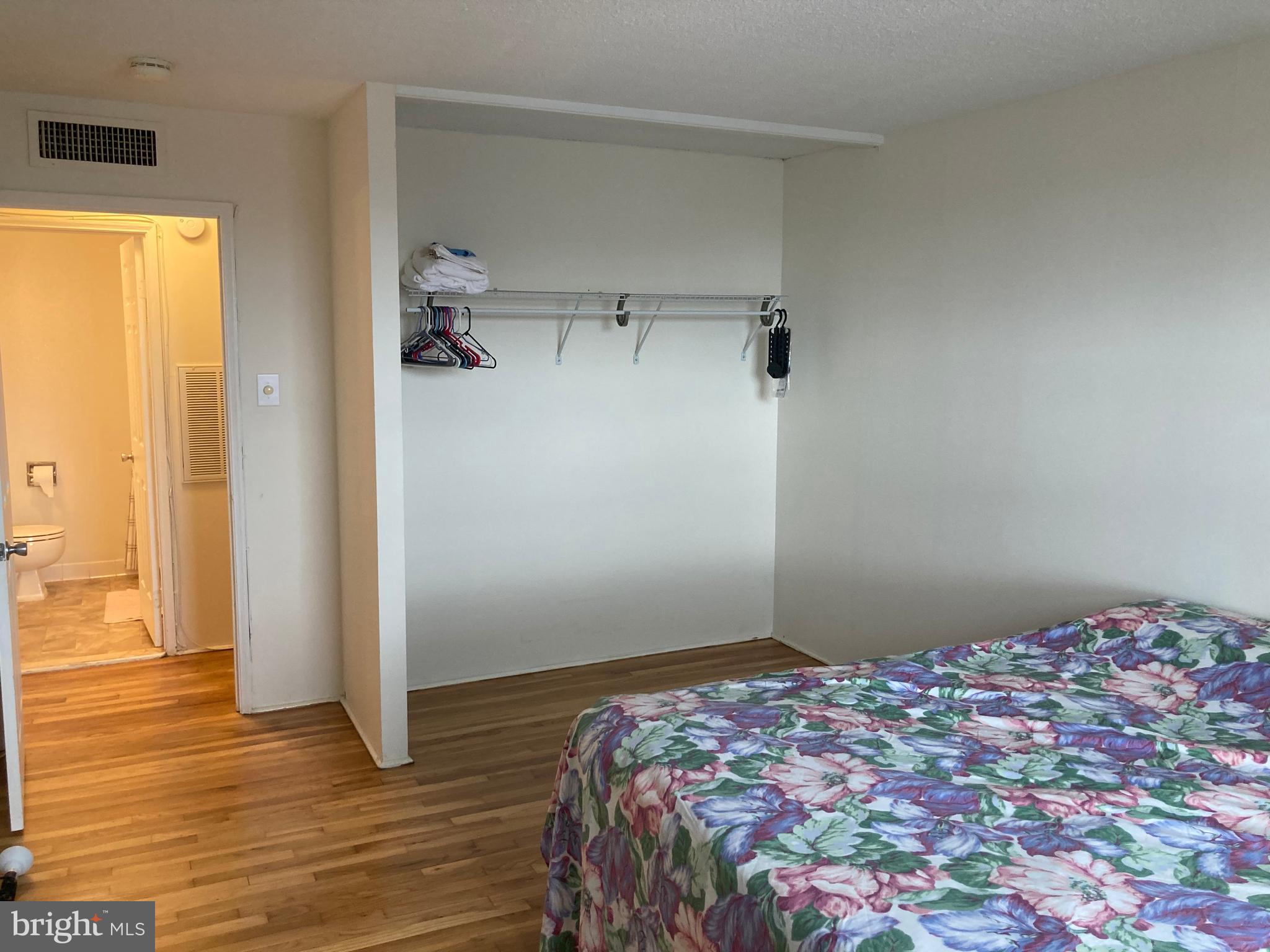 1101 St Paul Street, Unit 1403 Baltimore, MD 21202 - Photo 9 of 13 a bedroom with a bed and wooden floor
