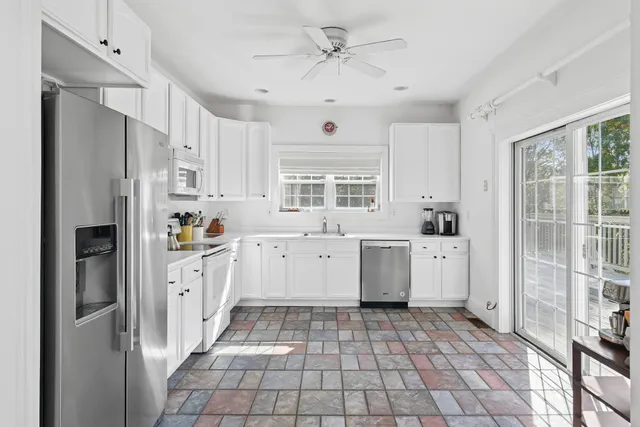 a kitchen with white cabinets and white appliances