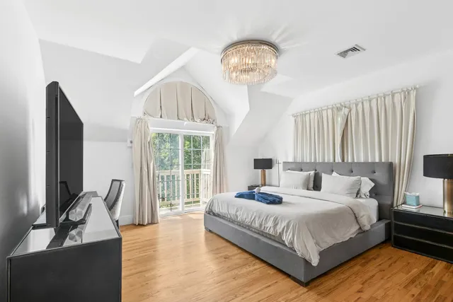 a bedroom with bed and a large window