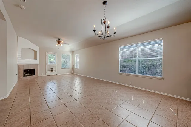 a view of an empty room with a window and fireplace