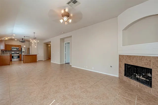 a view of a livingroom with a fireplace a chandelier and windows