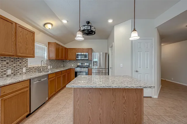 a large kitchen with kitchen island a large island in it