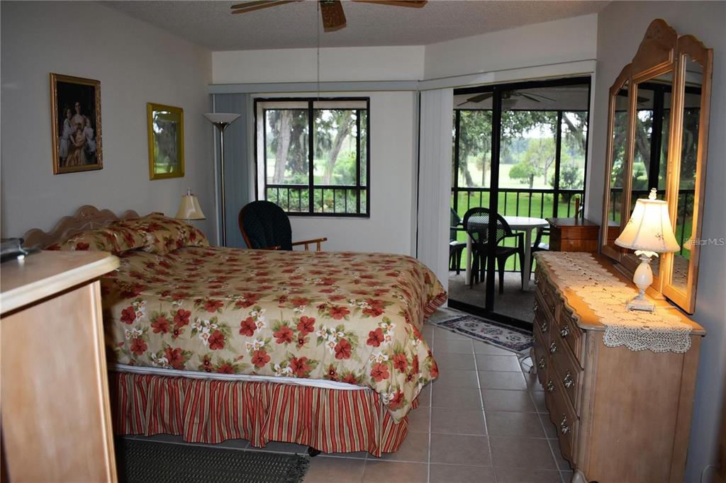 1716 Golf View Drive, Unit 1716 Tarpon Springs, FL 34689 - Photo 11 of 32 a bedroom with a bed and large windows